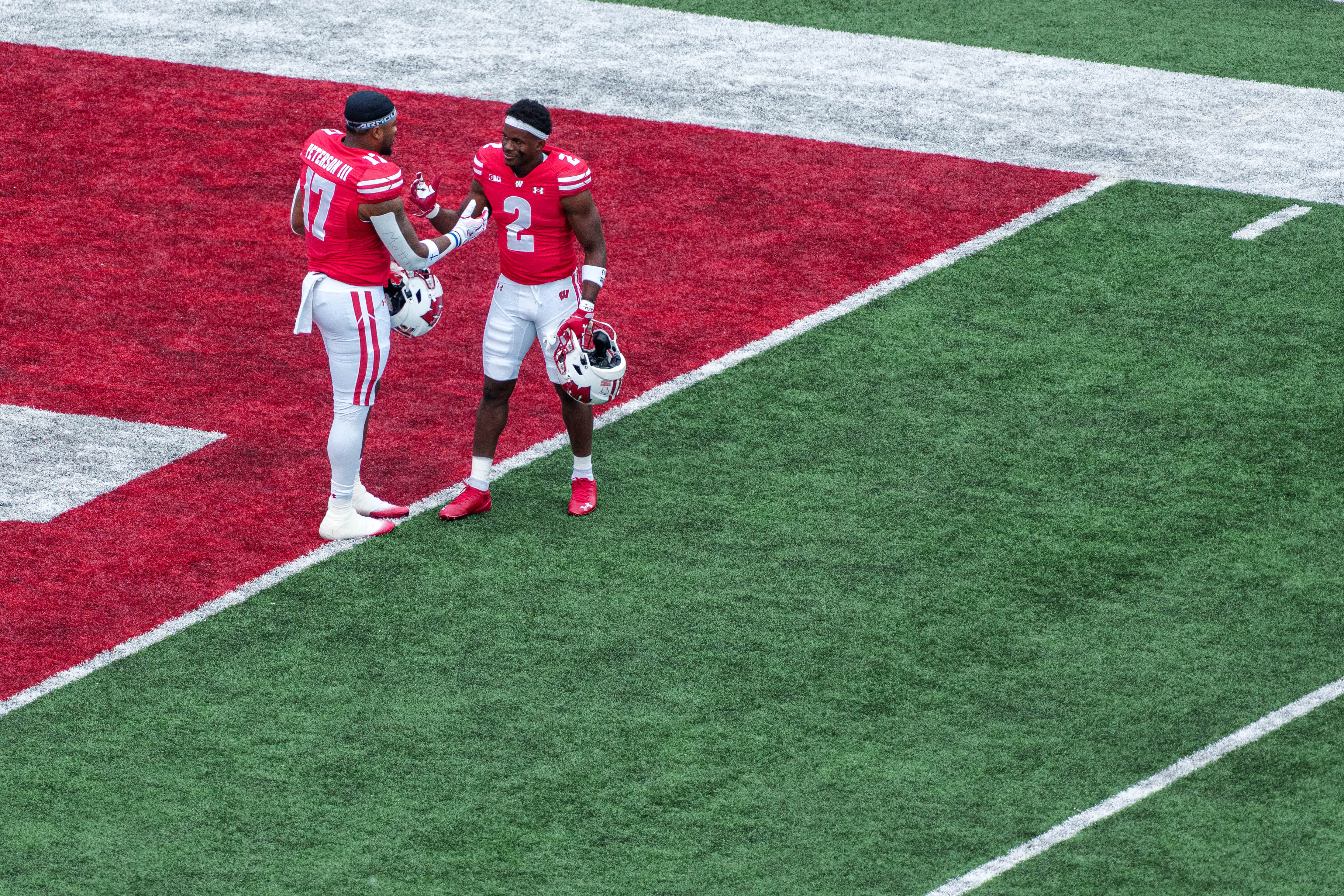 Sept 6, 2025; Madison, Wisconsin, USA; Wisconsin Badgers outside linebacker Darryl Peterson III (17) and cornerback Ricardo Hallman (2) shake hands before a college football game between the Wisconsin Badgers and the Middle Tennessee Blue Raiders at Camp Randall Stadium on September 06, 2025 in Madison, Wisconsin. Photography by Ross Harried for Second Crop Sports.