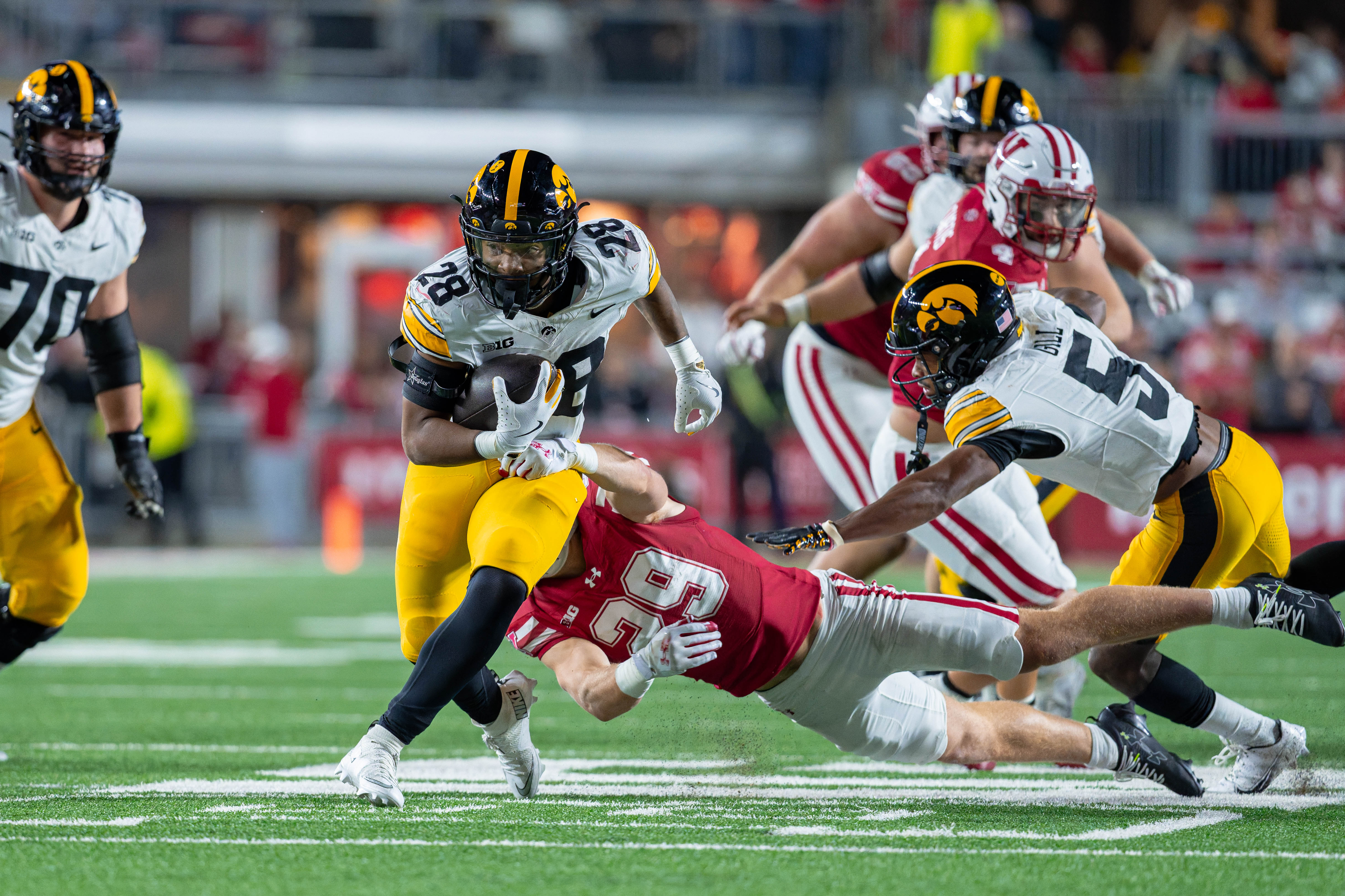 Oct 11, 2025; Madison, Wisconsin, USA; Iowa Hawkeyes running back Kamari Moulton (28) breaks away from a tackle by Wisconsin Badgers safety Matthew Jung (29) in the first half at Camp Randall Stadium. Mandatory Credit Photography by Ross Harried for Second Crop Sports.