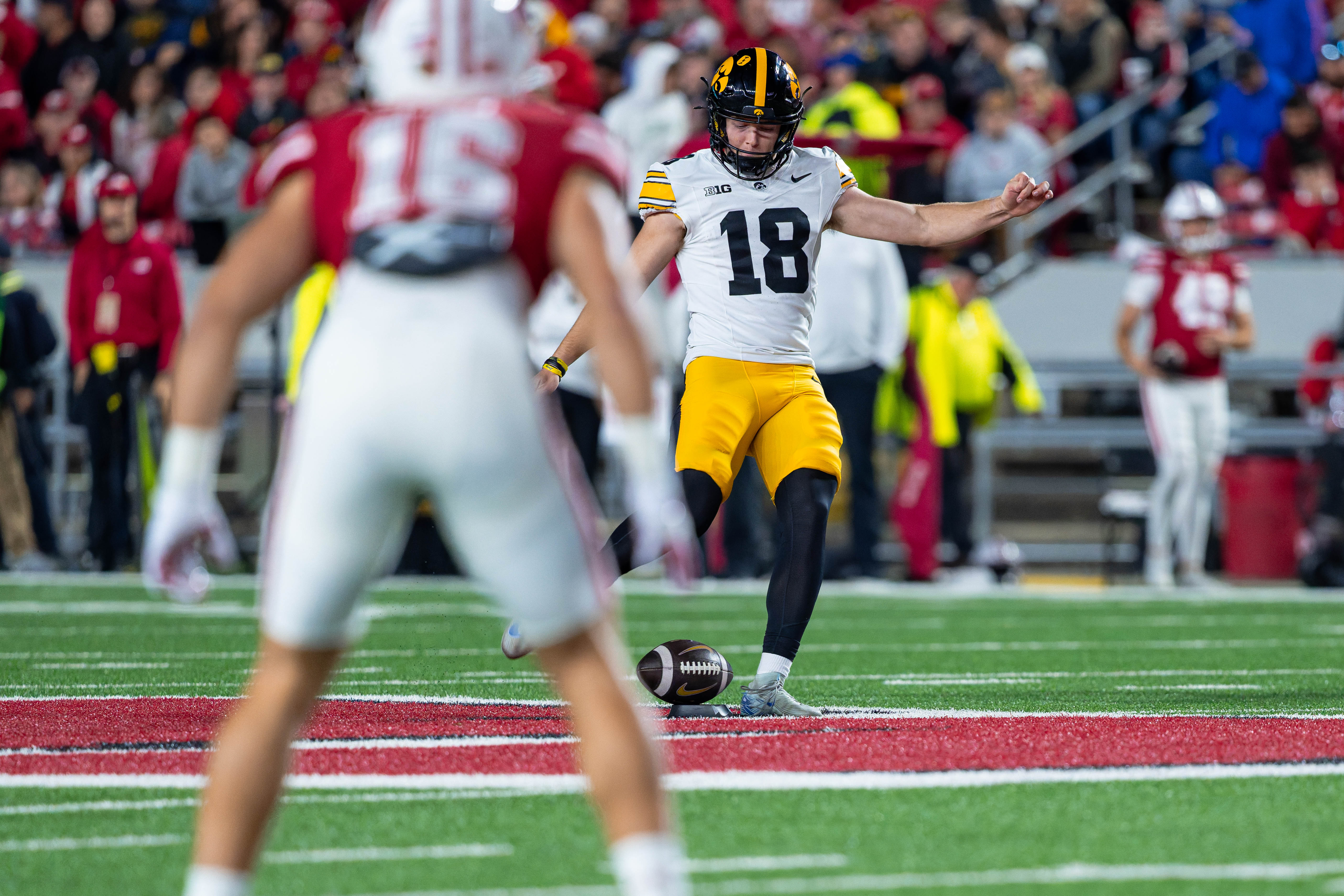 Oct 11, 2025; Madison, Wisconsin, USA; Iowa Hawkeyes kicker Drew Stevens (18) attempts a squib kick in the first half against the Wisconsin Badgers at Camp Randall Stadium. Mandatory Credit Photography by Ross Harried for Second Crop Sports.