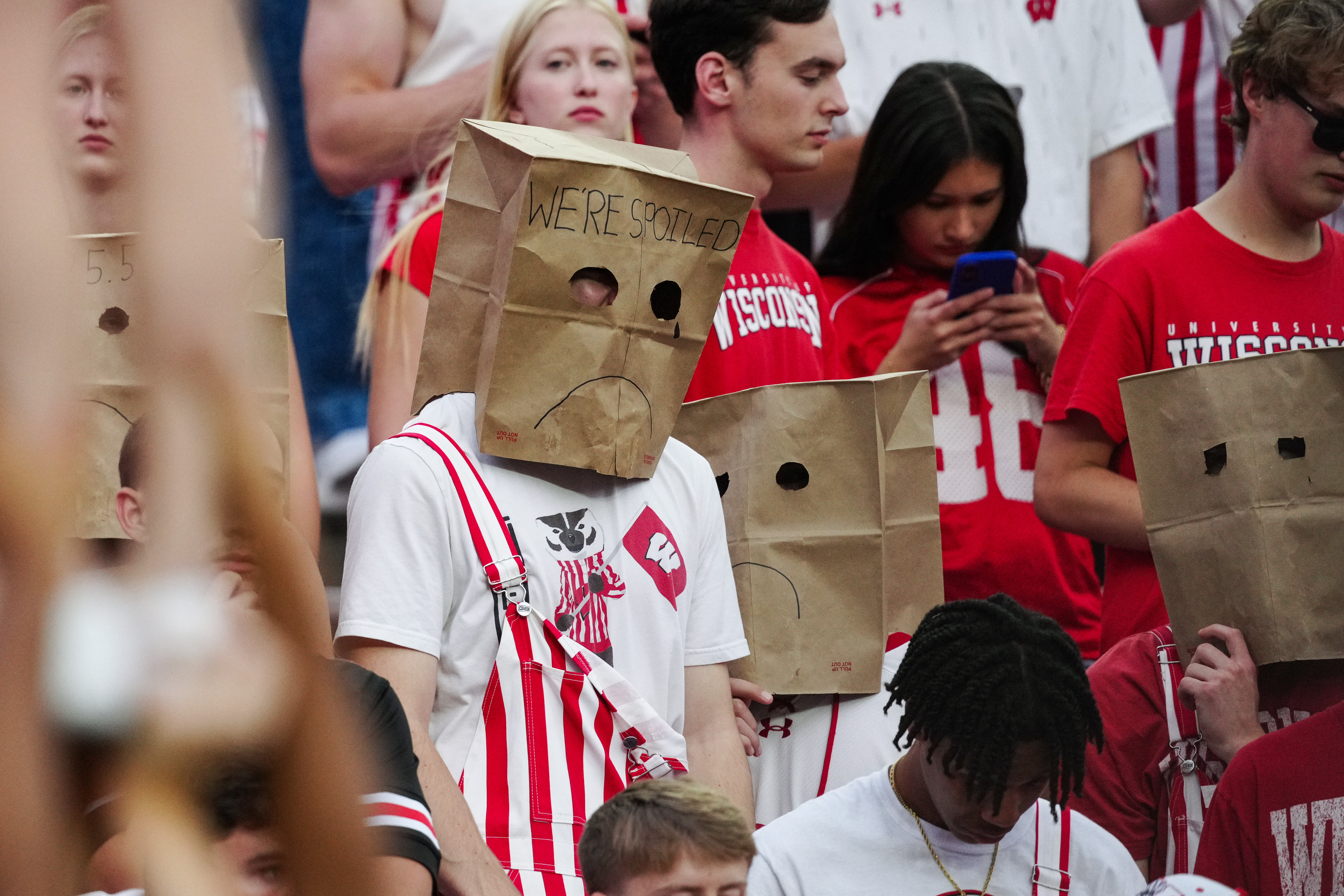 Oct 18, 2025; Madison, Wisconsin, USA; Wisconsin Badgers fans hide their faces in the second half against the Ohio State Buckeyes at Camp Randall Stadium on October 18, 2025 in Madison, Wisconsin. Photography by Ross Harried for Second Crop Sports.