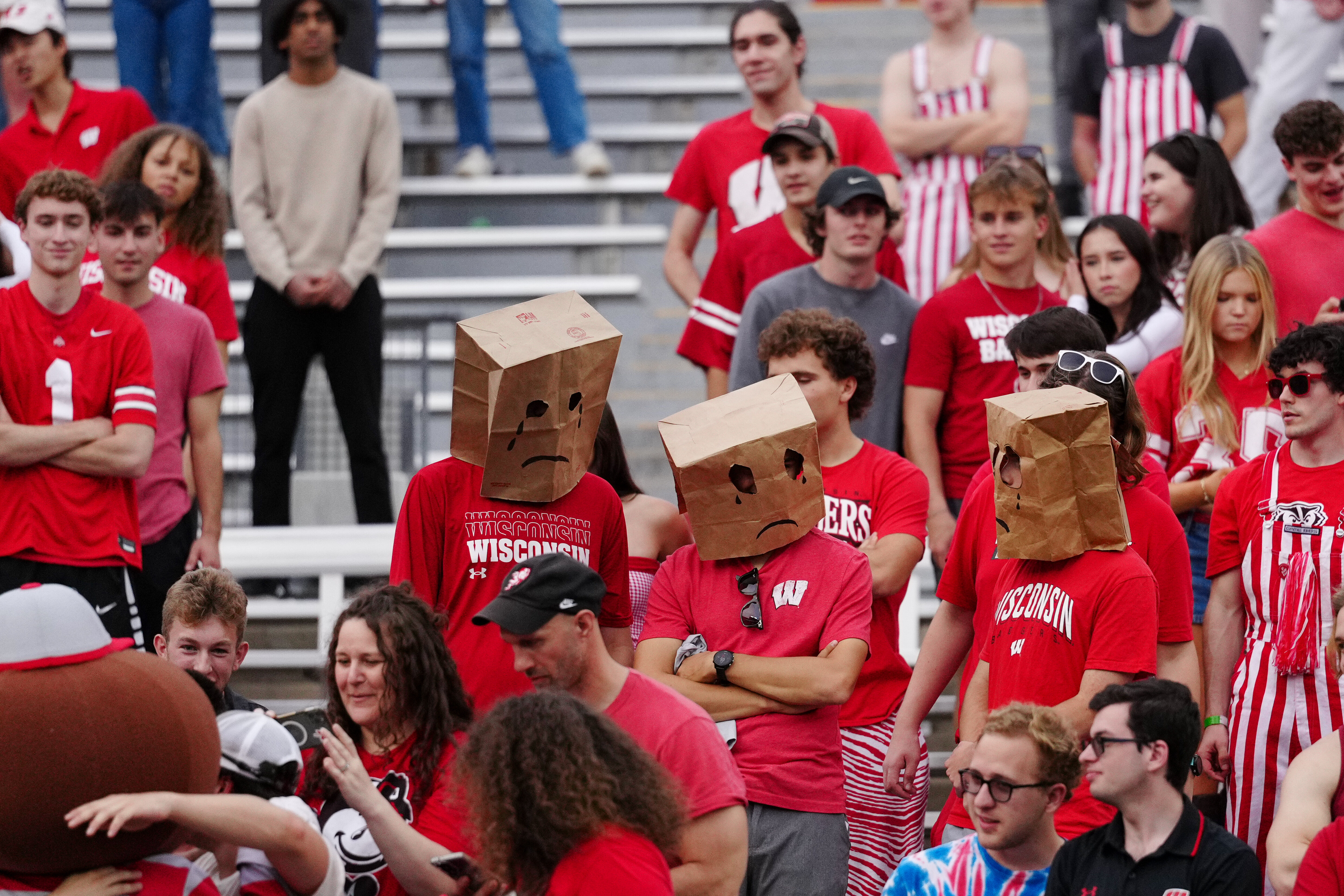 Oct 18, 2025; Madison, Wisconsin, USA; Wisconsin Badgers fans hide their faces in the second half against the Ohio State Buckeyes at Camp Randall Stadium on October 18, 2025 in Madison, Wisconsin. Photography by Ross Harried for Second Crop Sports.